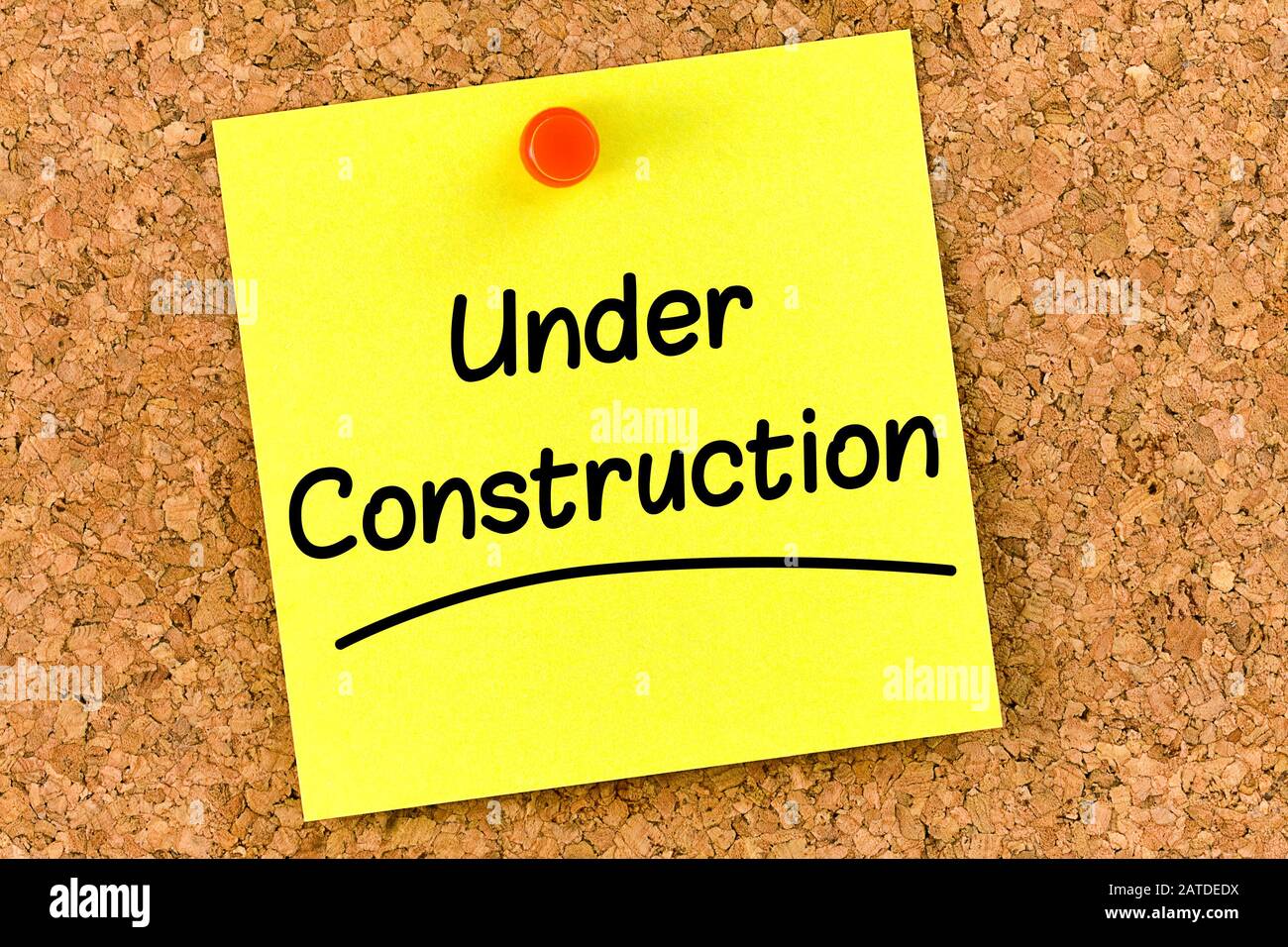 Closeup post it note on corkboard with under construction message on it Stock Photo Alamy
