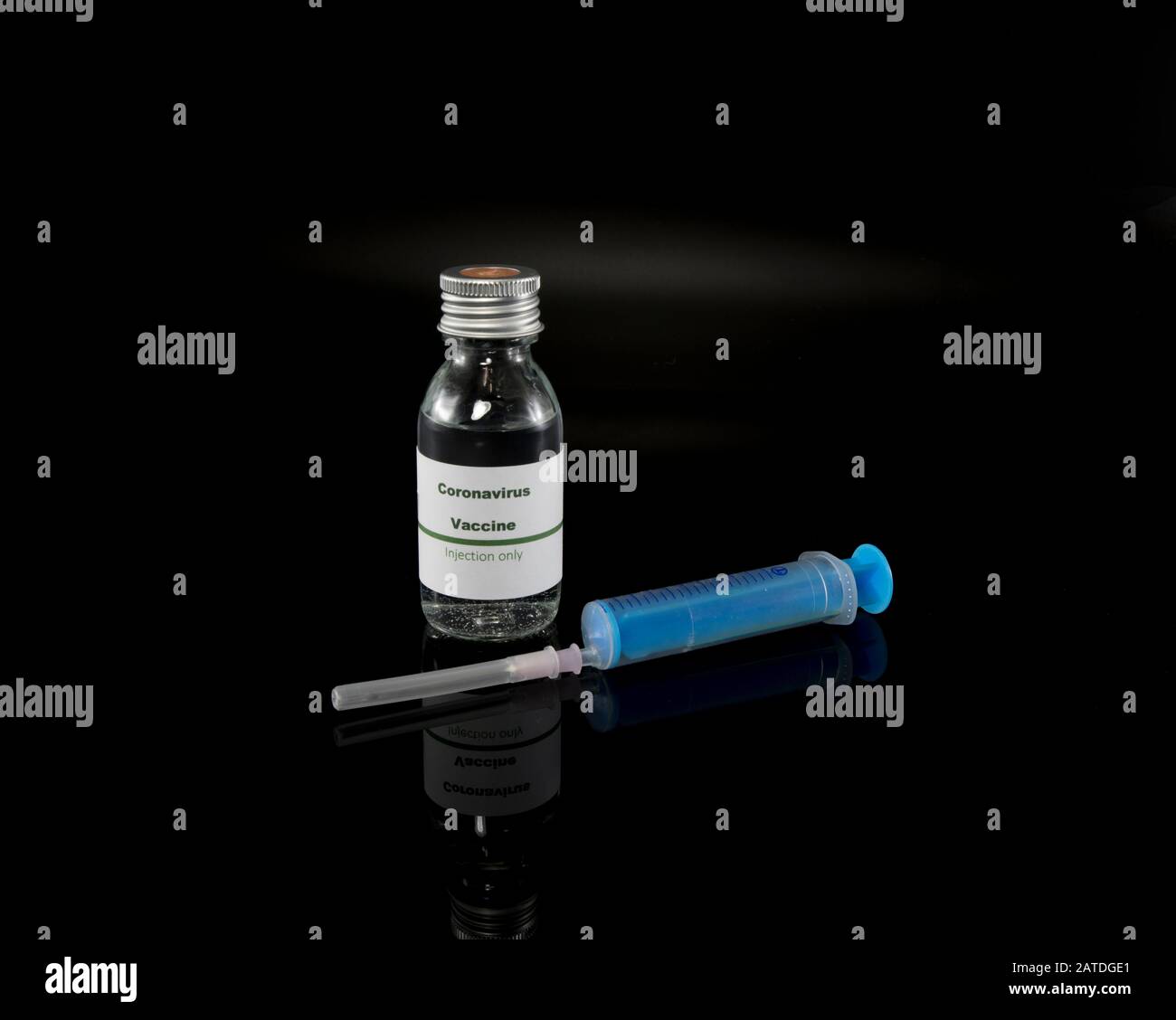 Coronavirus vaccine vial with injection syringe isolated on black background Stock Photo