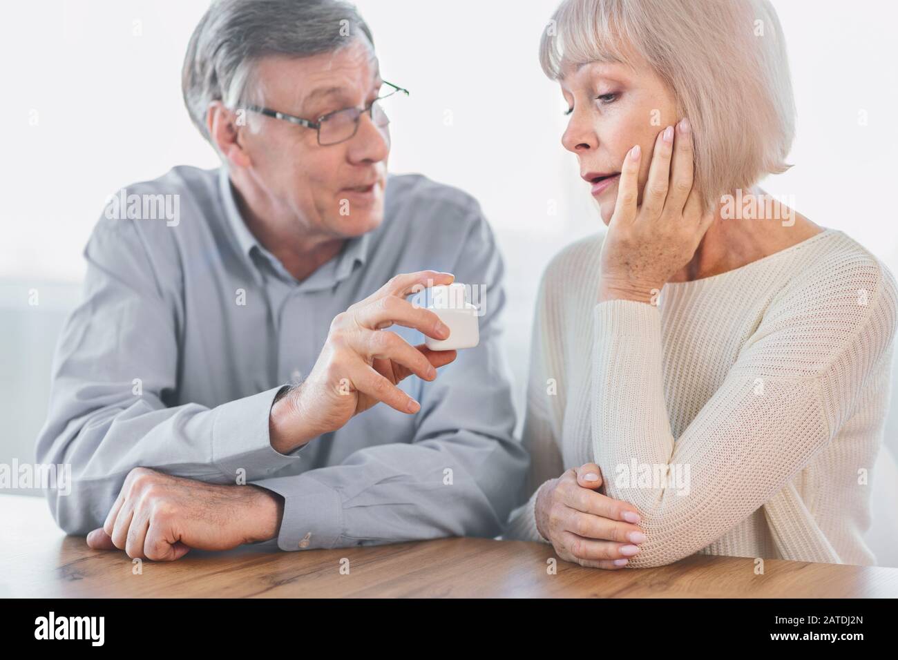 Mature man giving his wife some pills Stock Photo