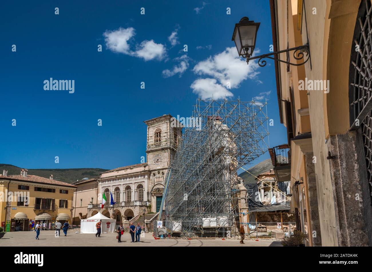 Palazzo Comunale, damaged, and facade, supported by scaffolding, of Basilica of San Benedetto, destroyed by earthquakes, in Norcia, Umbria, Italy Stock Photo