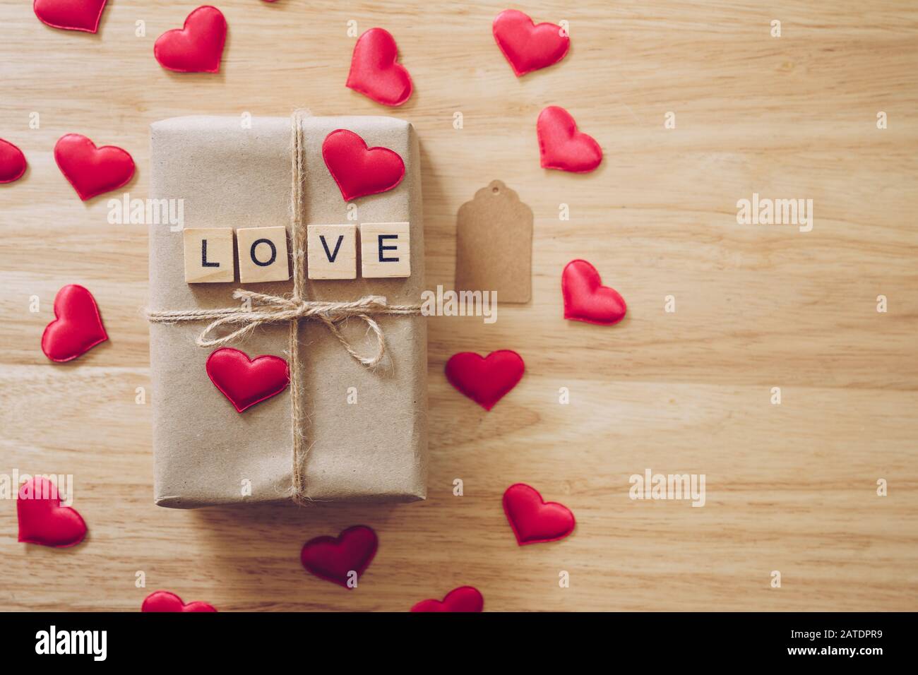Top view brown gift box and red heart on wood background for valentine day with copy space. Stock Photo