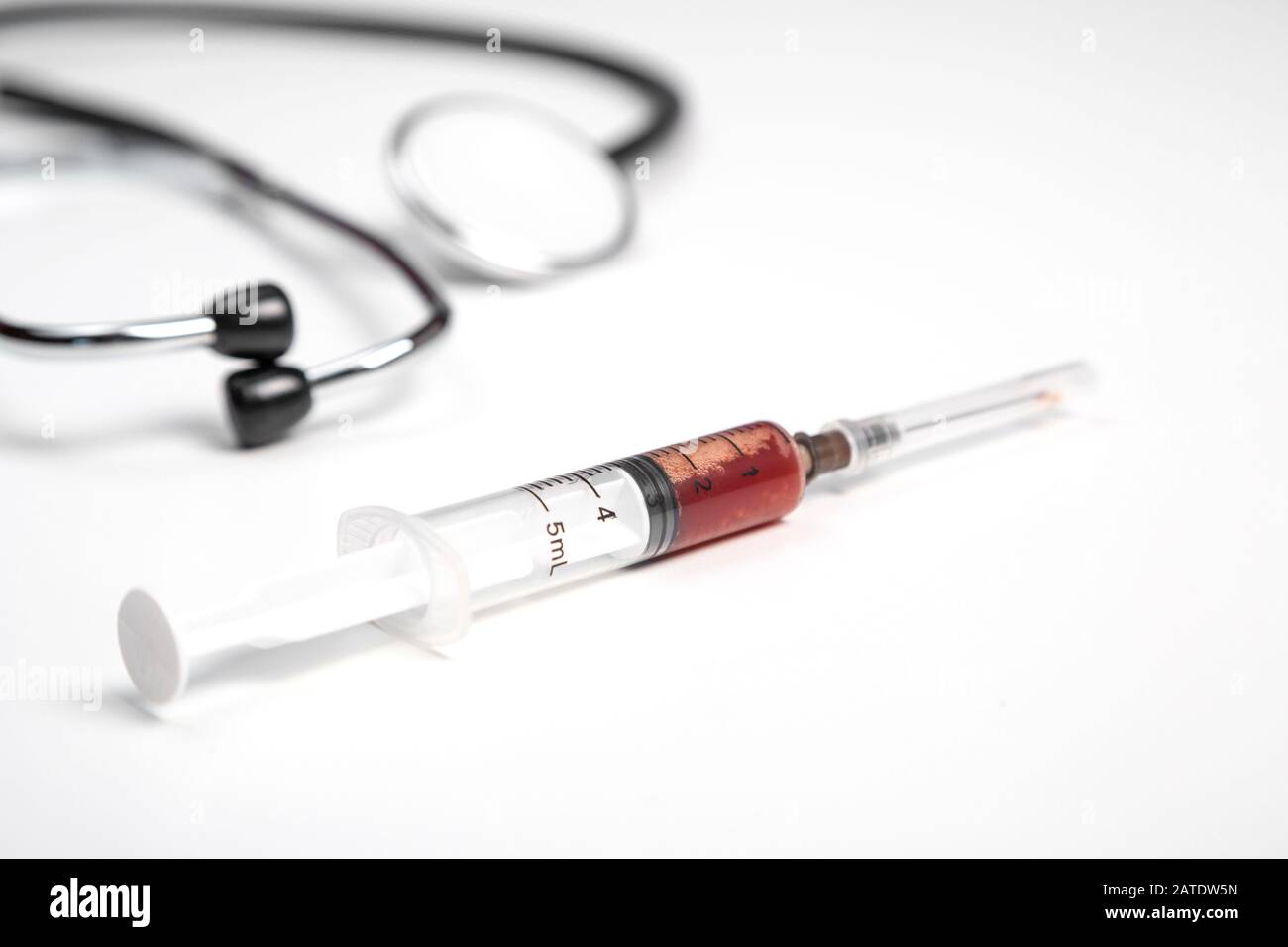 medical stethoscope and syringe with blood samples on a white isolated ...