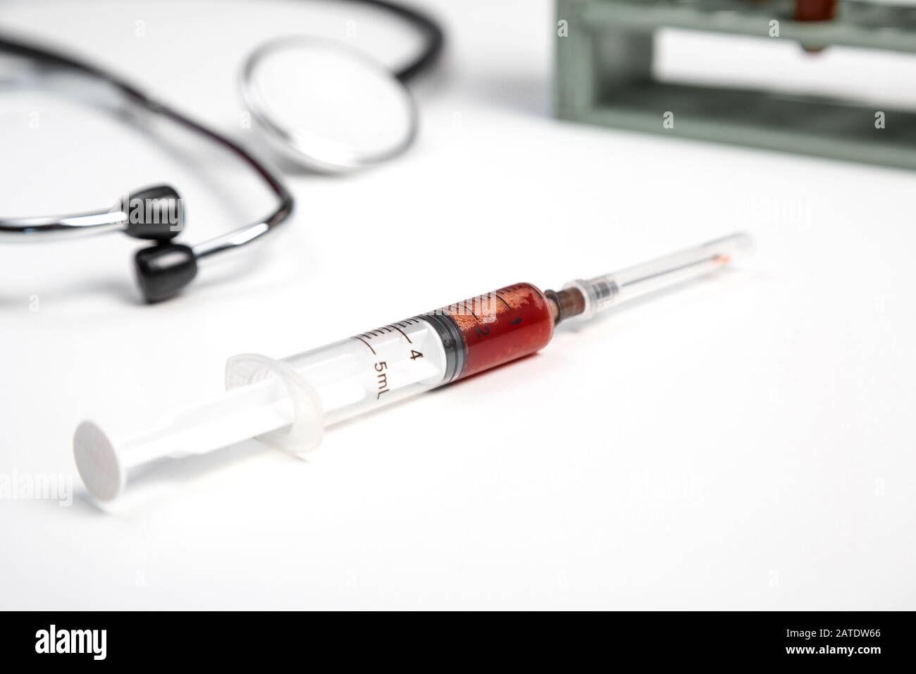 medical stethoscope and syringe with blood samples on a white isolated ...