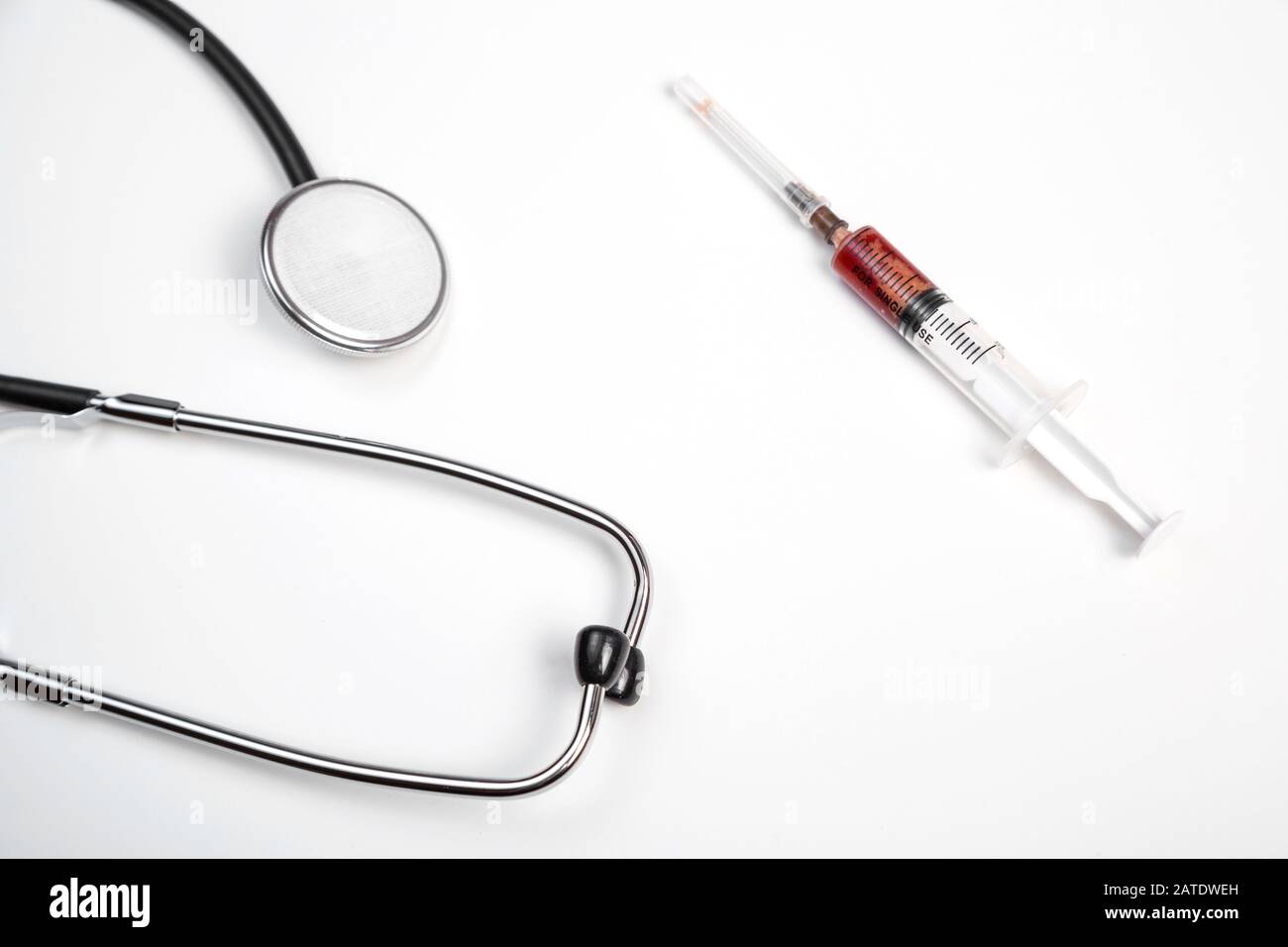 medical stethoscope and syringe with blood samples on a white isolated ...