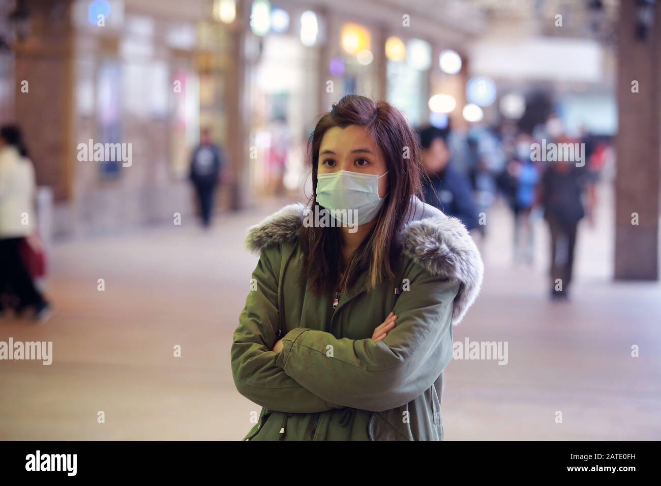 masked girl to protect herself from wuhan virus in public area Stock Photo