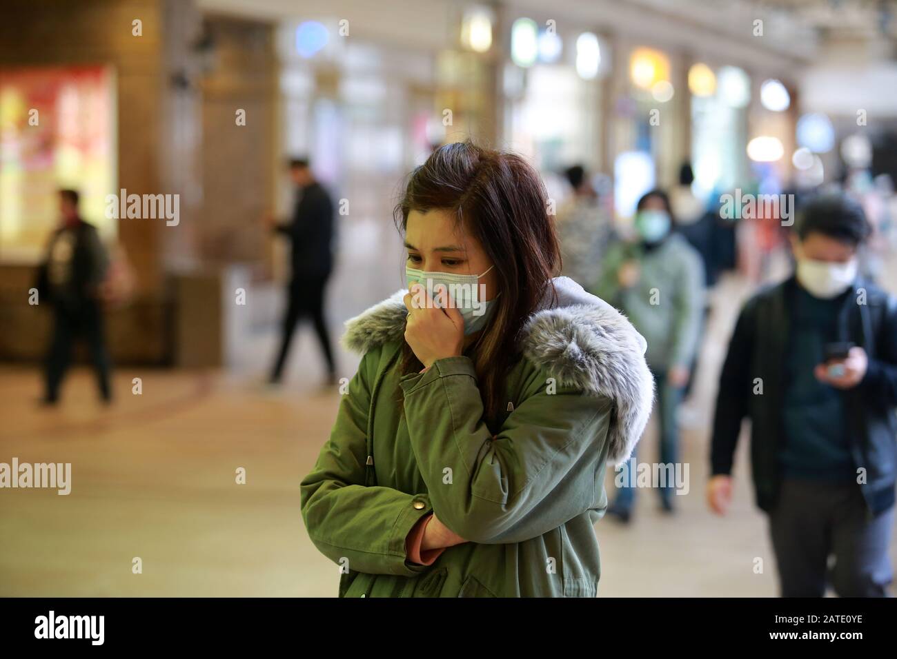 masked girl to protect herself from wuhan virus in public area Stock Photo