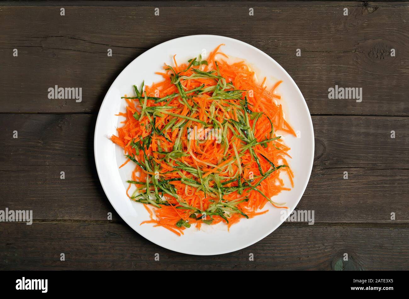 Vegetables salad with carrot and cucumber on wooden table, top view Stock Photo