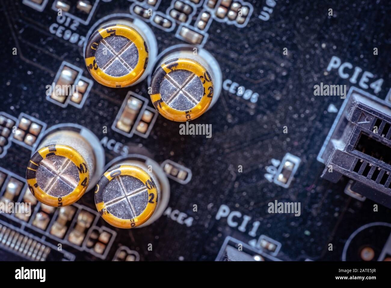 Yellow capacitors on the dark PC motherboard closeup Stock Photo