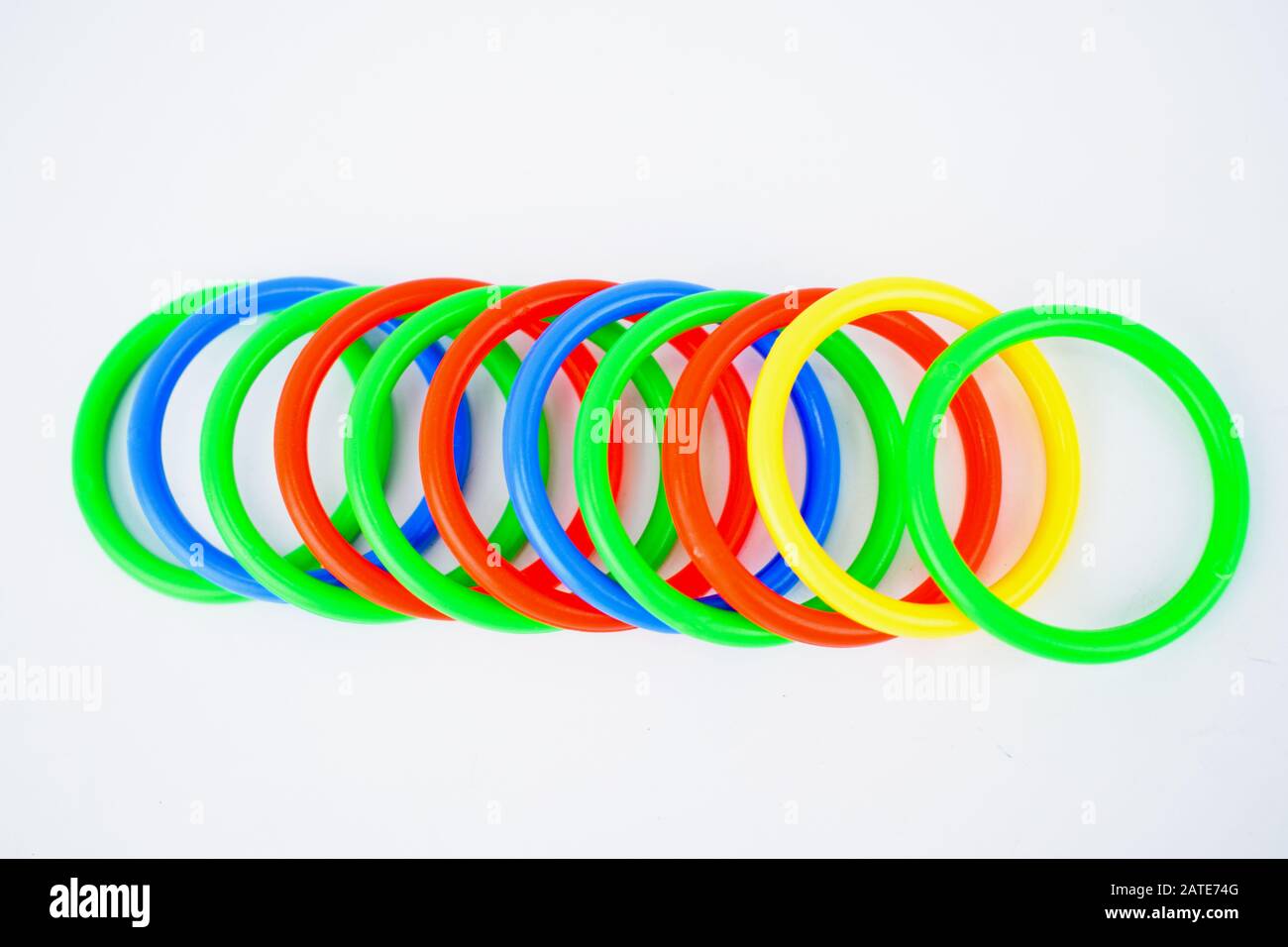 Multiple plastic circle shaped toys arranged on an isolated white background Stock Photo