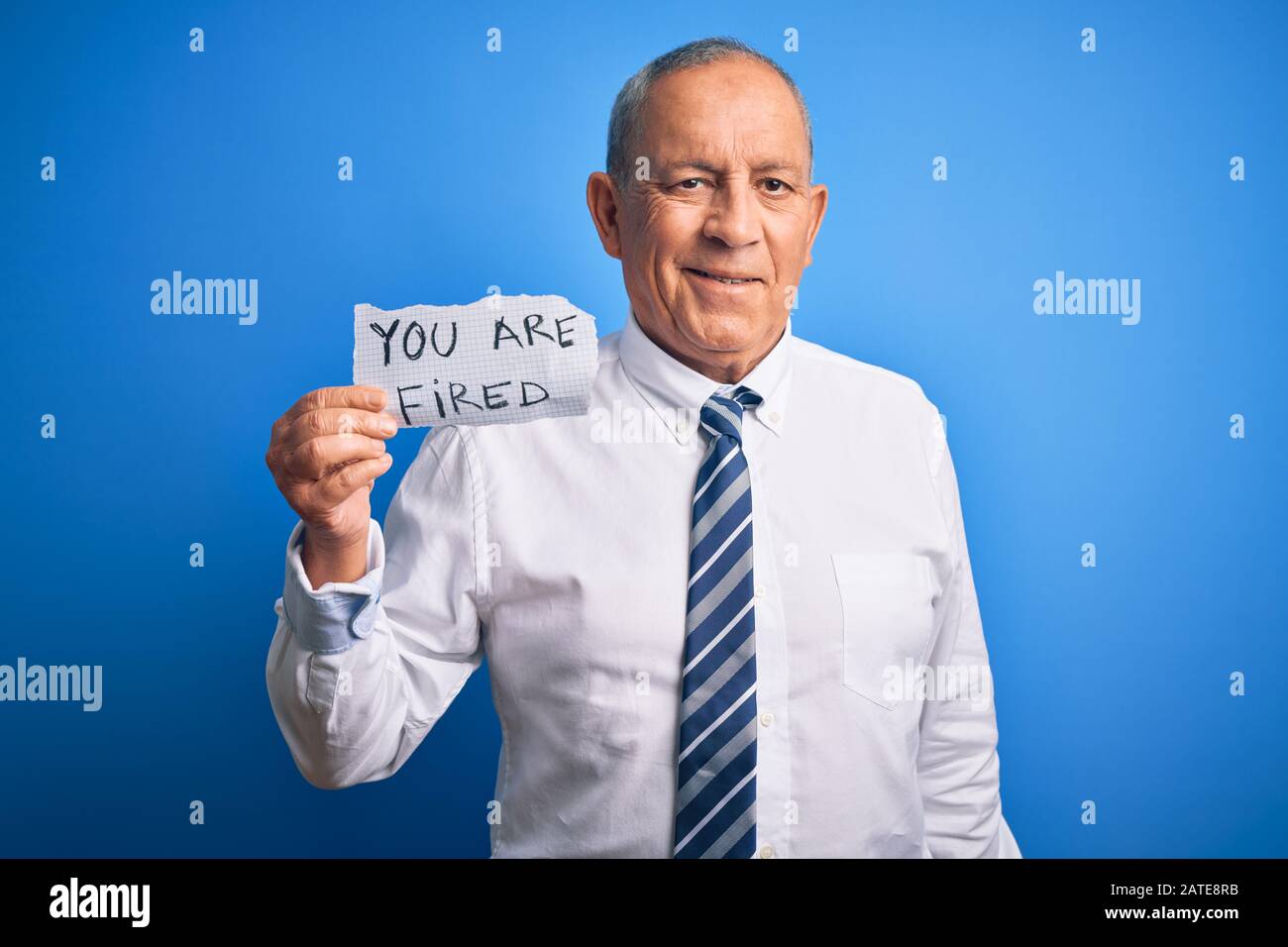 Senior handsome businessman holding you are fired paper over isolated ...
