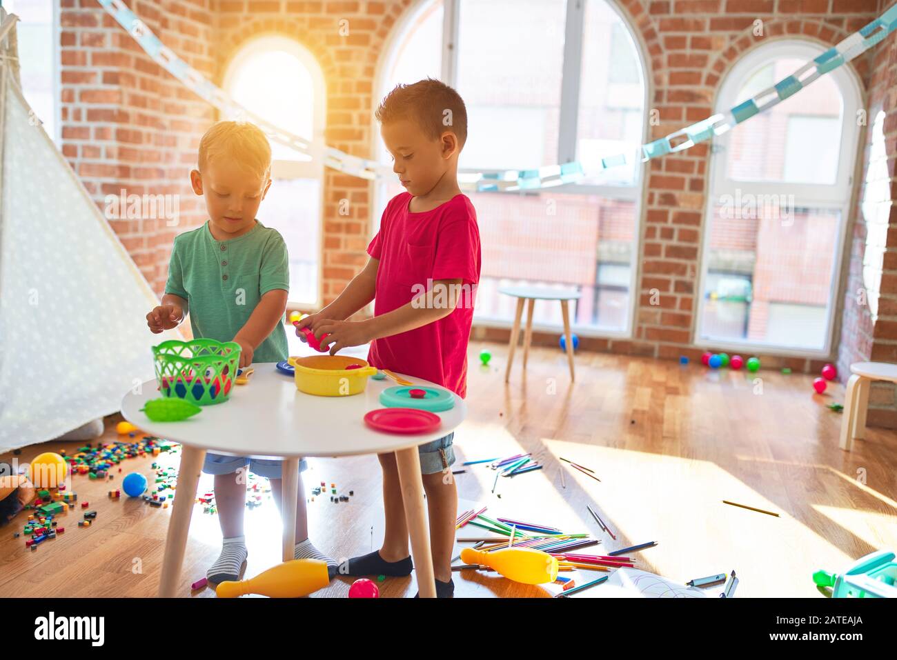 Adorable toddlers playing around lots of toys at kindergarten Stock Photo Alamy