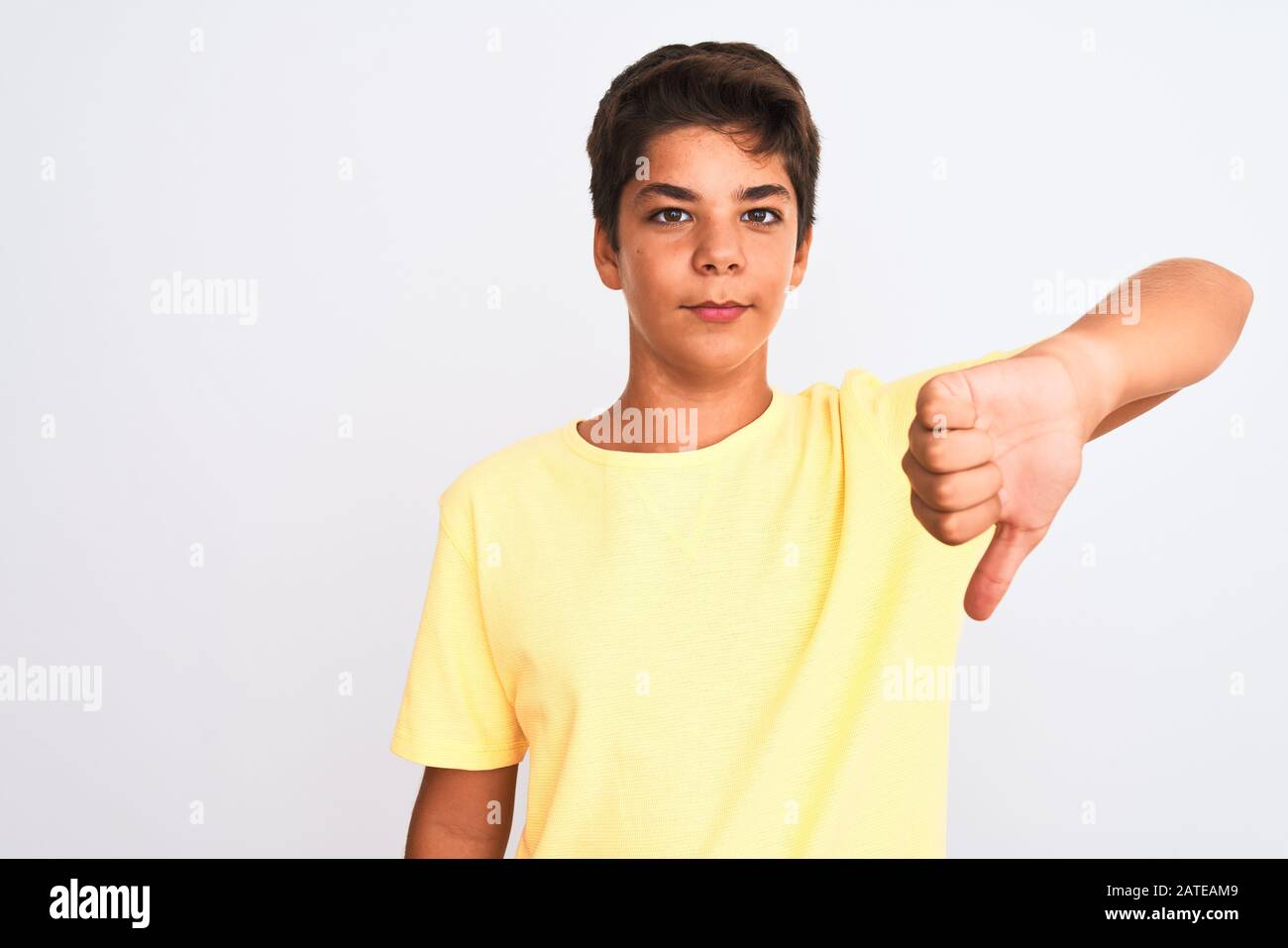 Handsome teenager boy standing over white isolated background looking ...