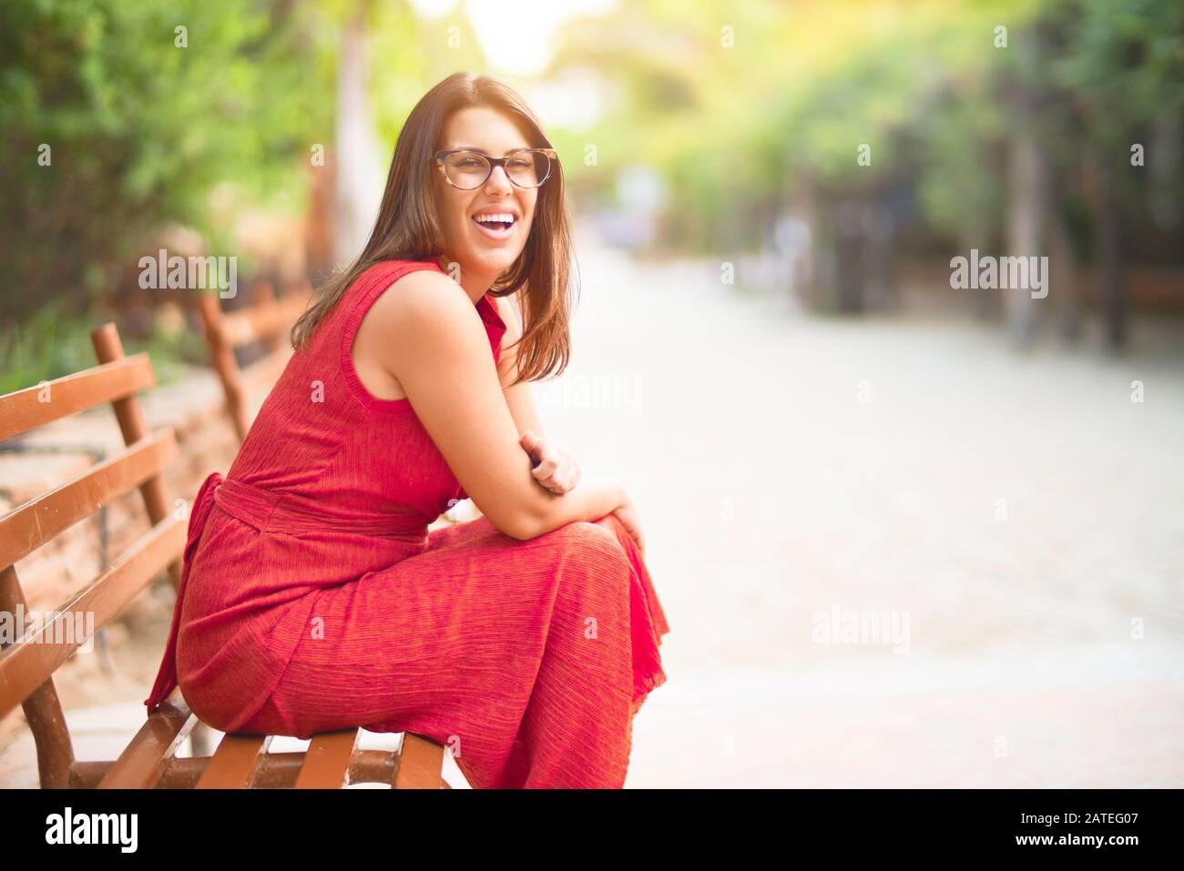 Young beautiful girl smiling happy and confident sitting on bench at ...