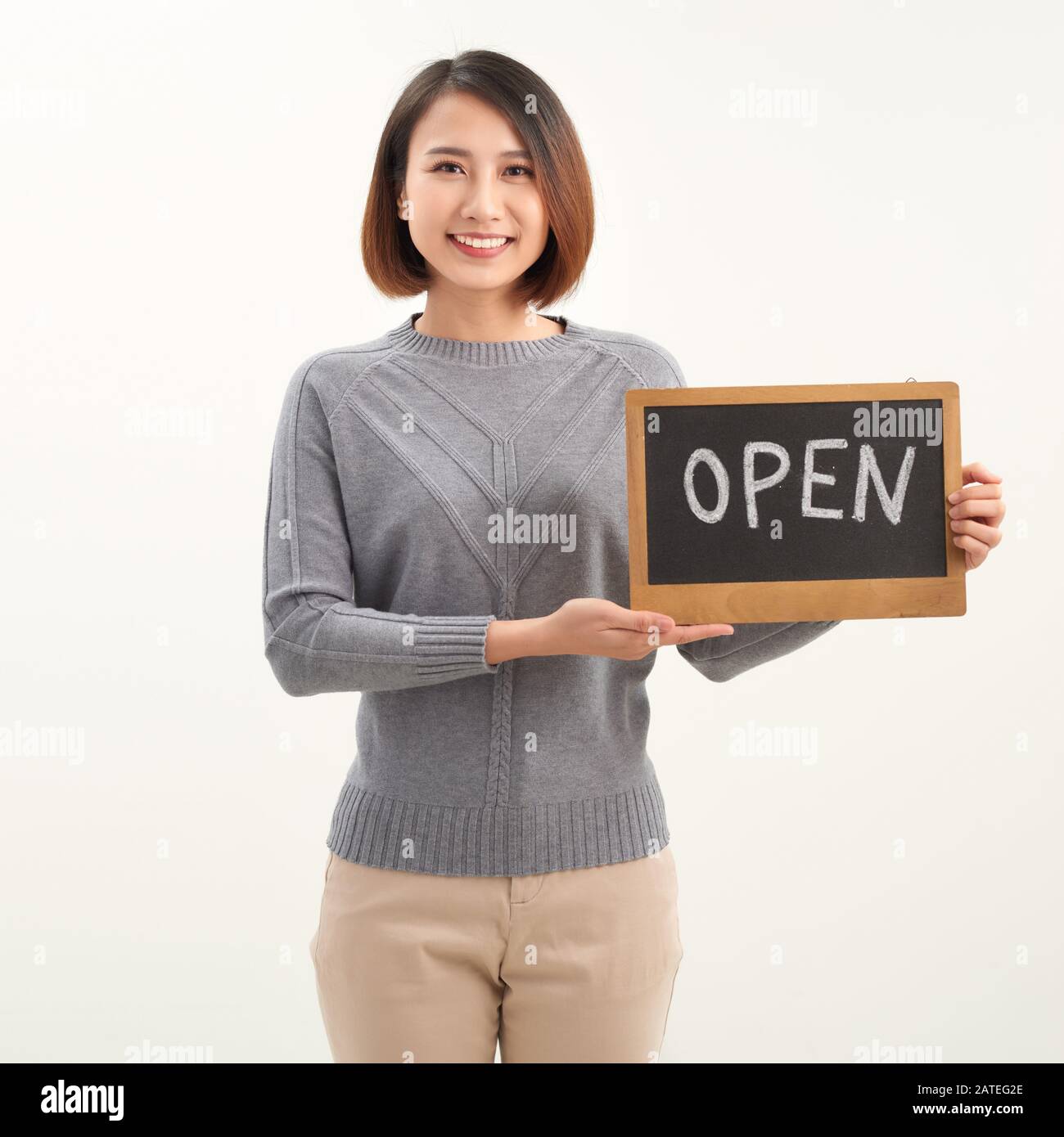 Portrait of young beautiful Asian cafe owner holding open sign Stock Photo
