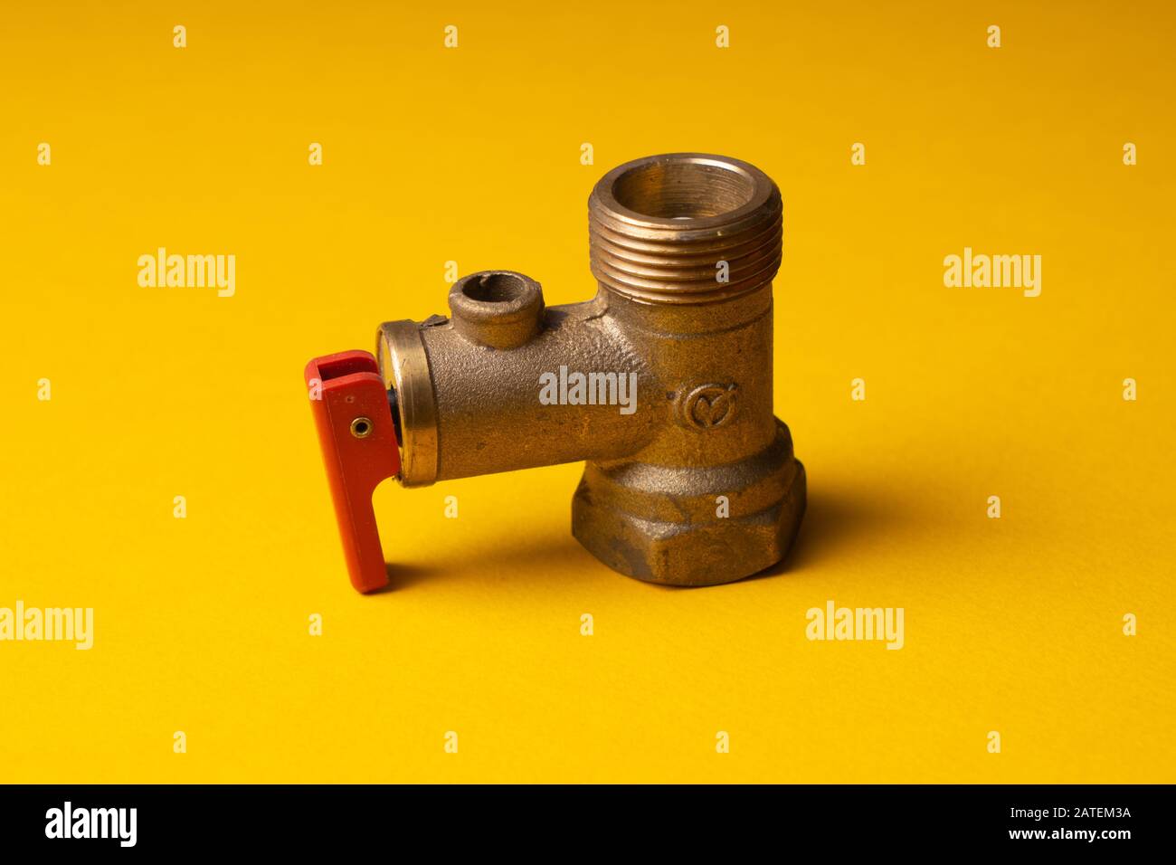 Bronze Check Valve. Non-return valve for water in the electric water heater system. On a yellow background Stock Photo