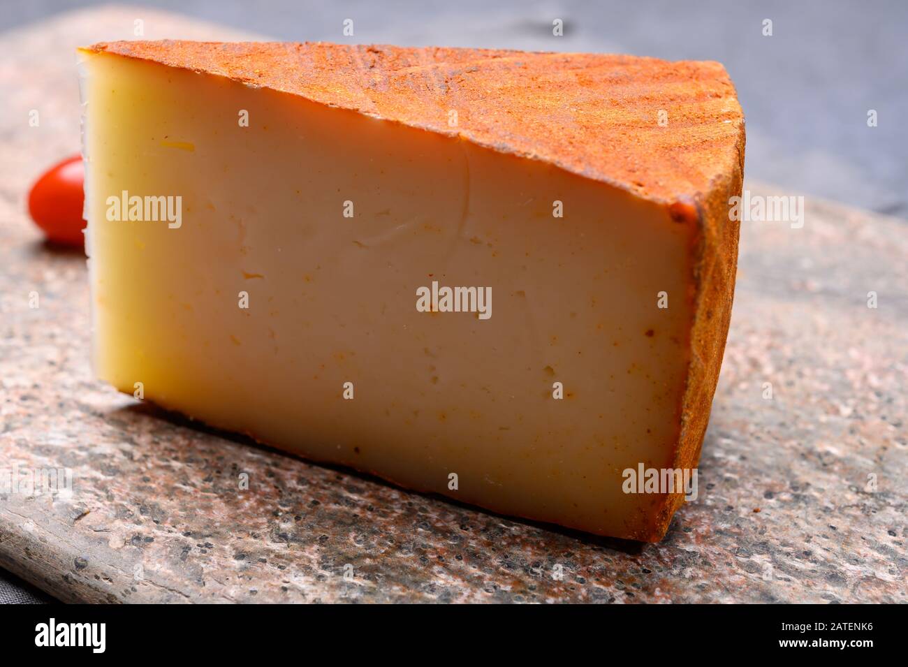 Cheese collection, piece of Spanish manchego cheese made from cow milk with red paprika close up