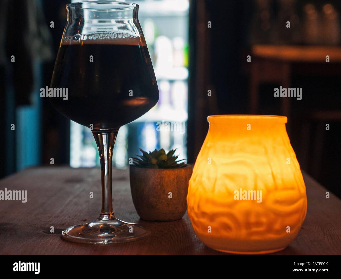 Imperial stout craft beer in a cozy bar with a candle light. Stock Photo