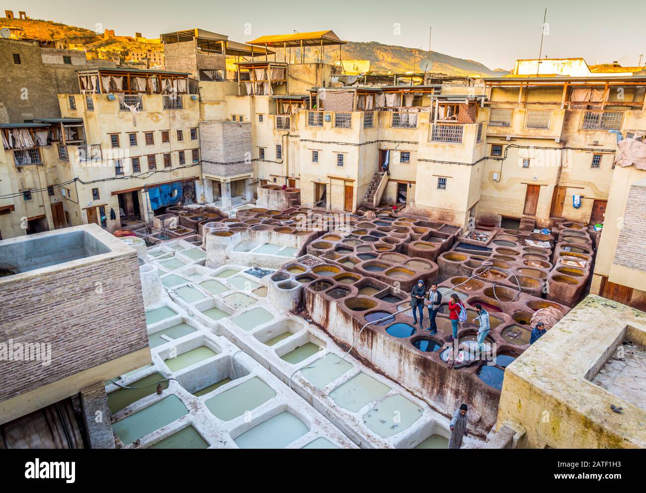 Tourists stand on stone vessels, tanneries, Fez, Morocco Stock Photo