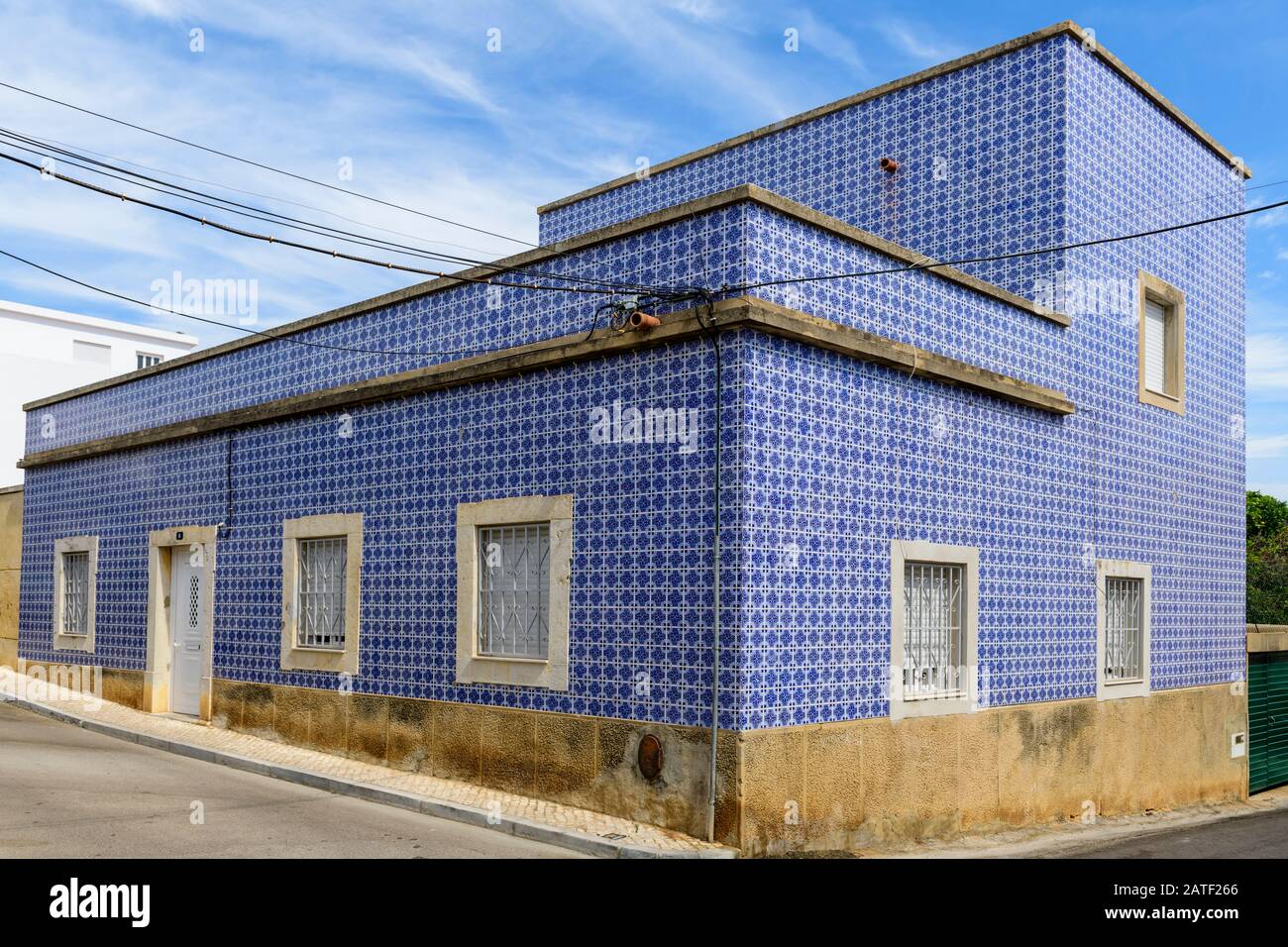 Typical tiled house in Fuseta, The houses are covered in tiles to protect the underlining structure from salt spray. Fuseta, Algarve, Portugal. Stock Photo