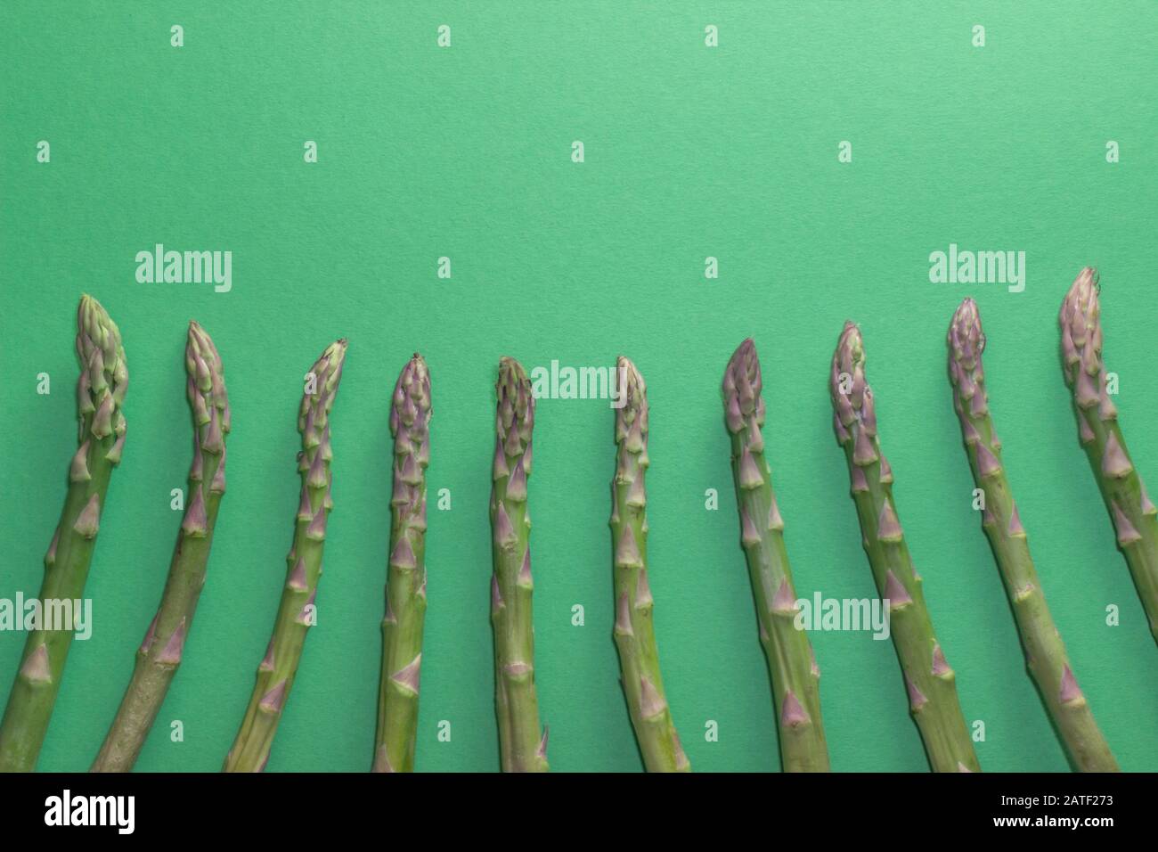 Green raw and healthy Asparagus on green Background. Detox and superfood Concept. Stock Photo
