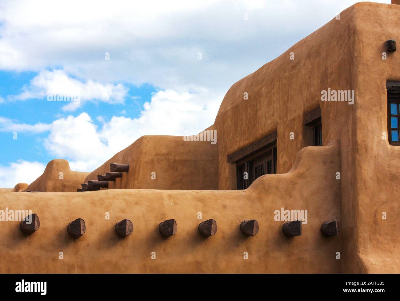 Pueblo adobe stucco stepped building. Contoured adobe plaster architecture with timber vigas. Santa Fe, New Mexico, USA Stock Photo