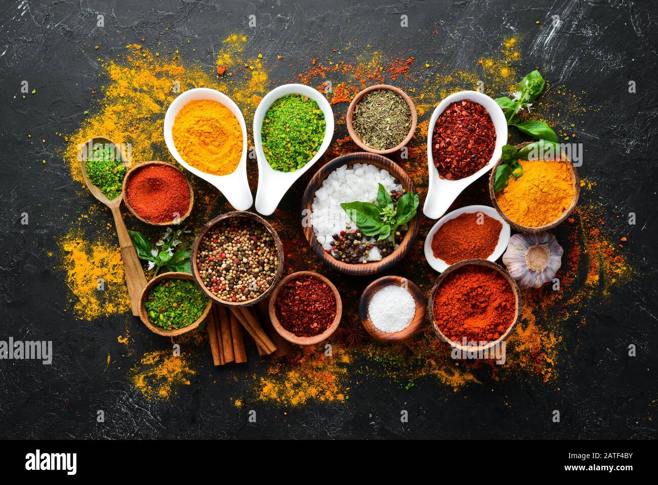 Colorful herbs and spices for cooking. Indian spices. On a black stone  background. Top view Stock Photo - Alamy