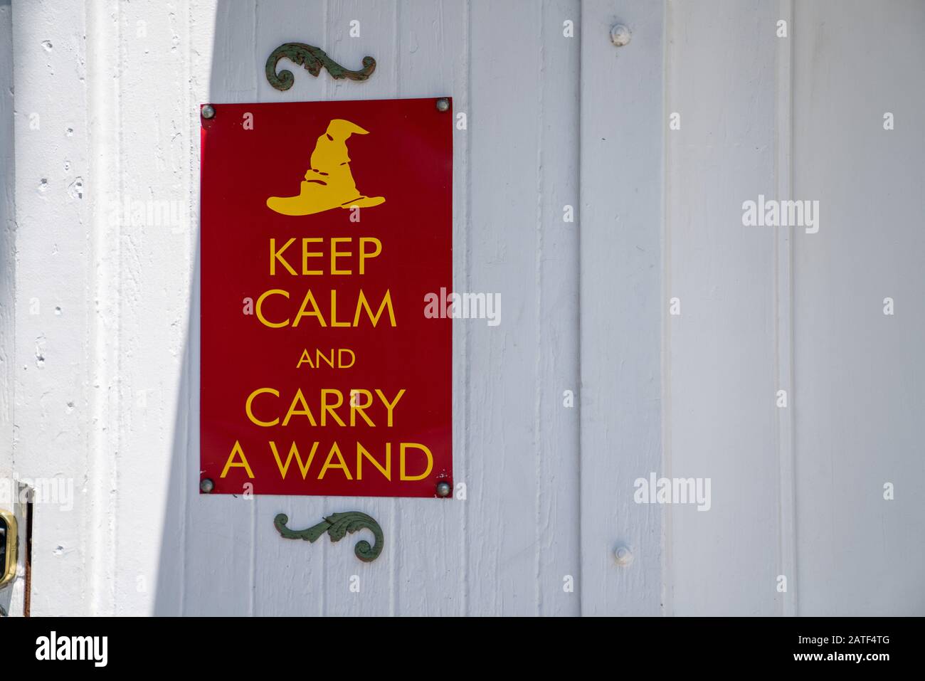 Keep calm and carry a wand gag humor sign hanging on wall Stock Photo