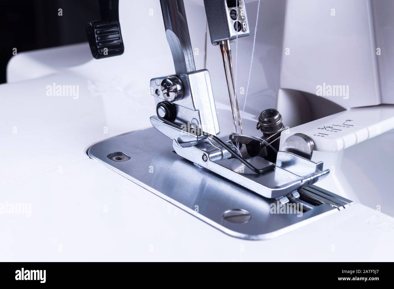 Presser foot of sewing machine with needle and thread close up. Detail
