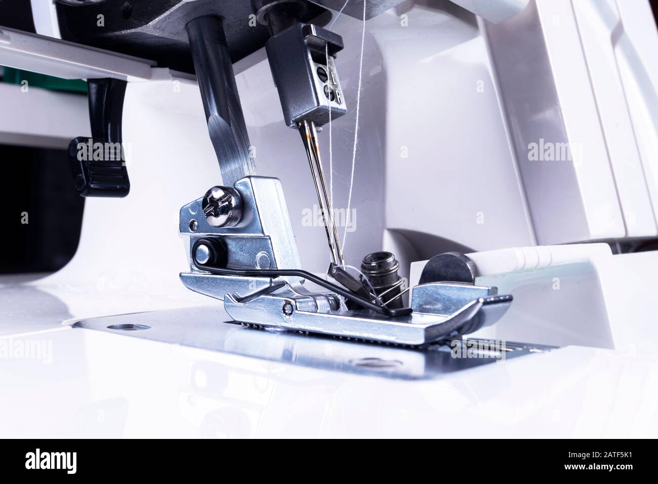 Presser foot of sewing machine with needle and thread close up. Detail