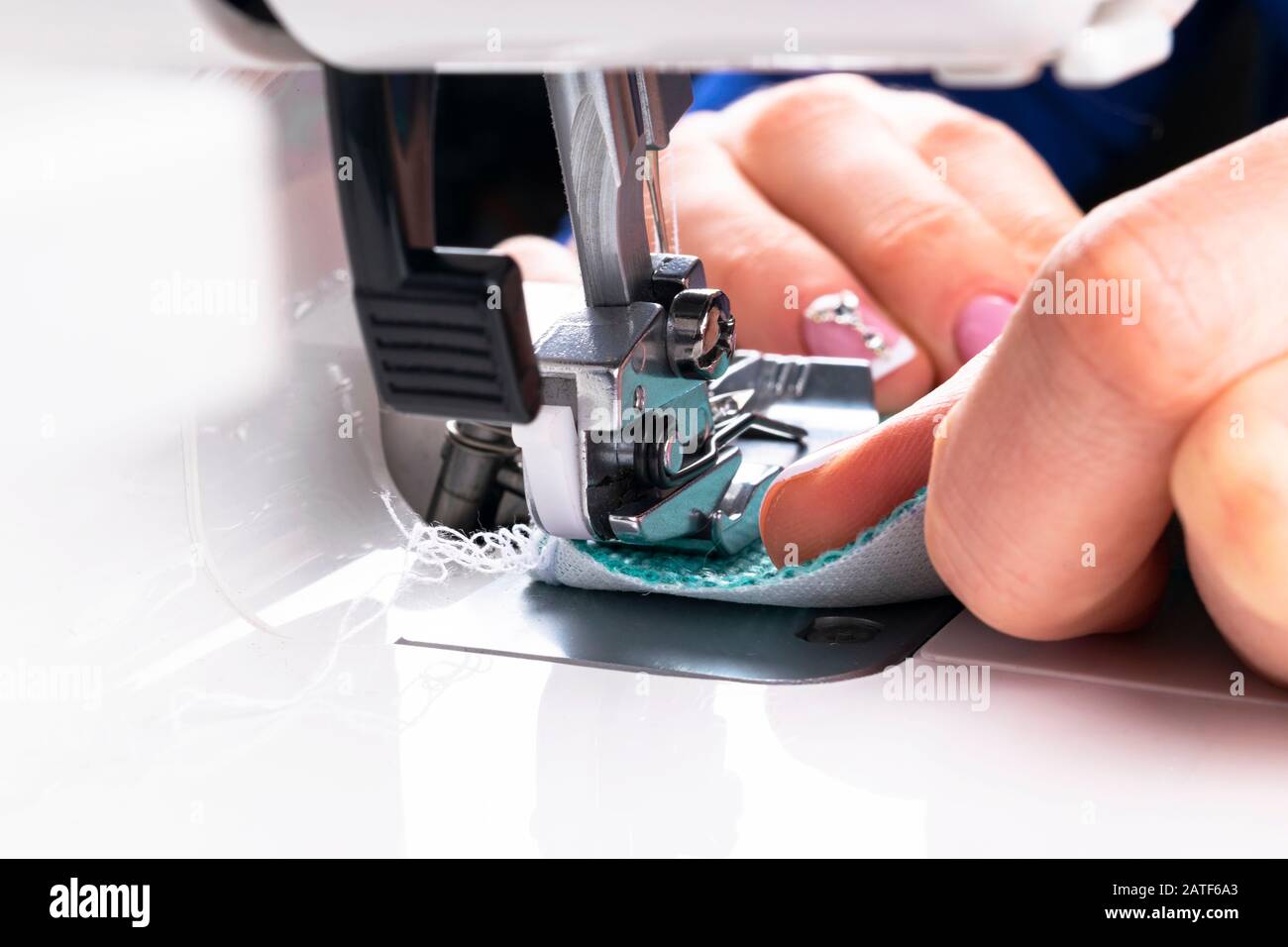 Presser foot of sewing machine with needle and thread close up. Detail ...
