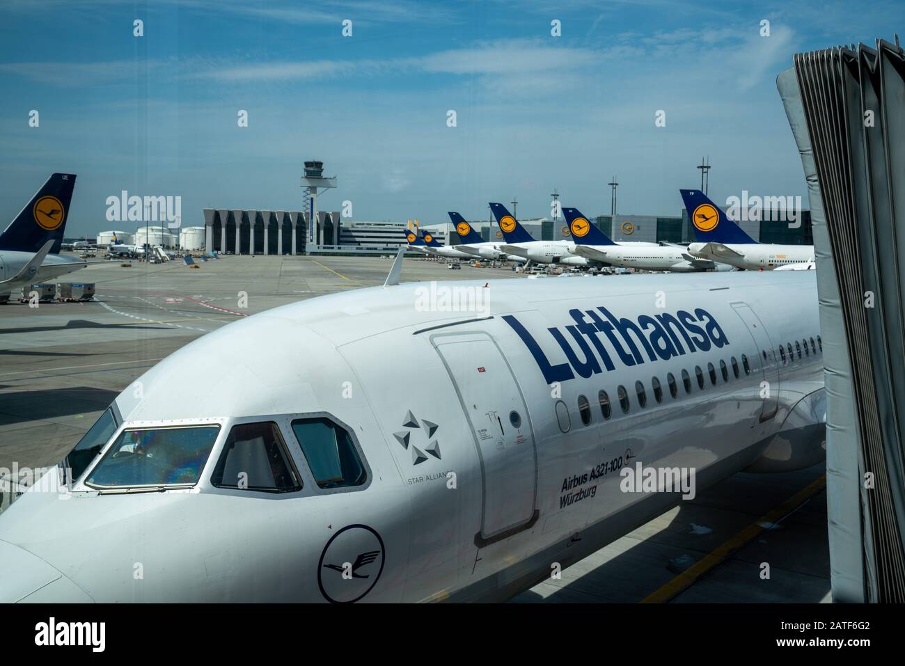 Deutsche Lufthansa AG logos Airbus aircraft at passenger boarding area with fleet in view Stock Photo