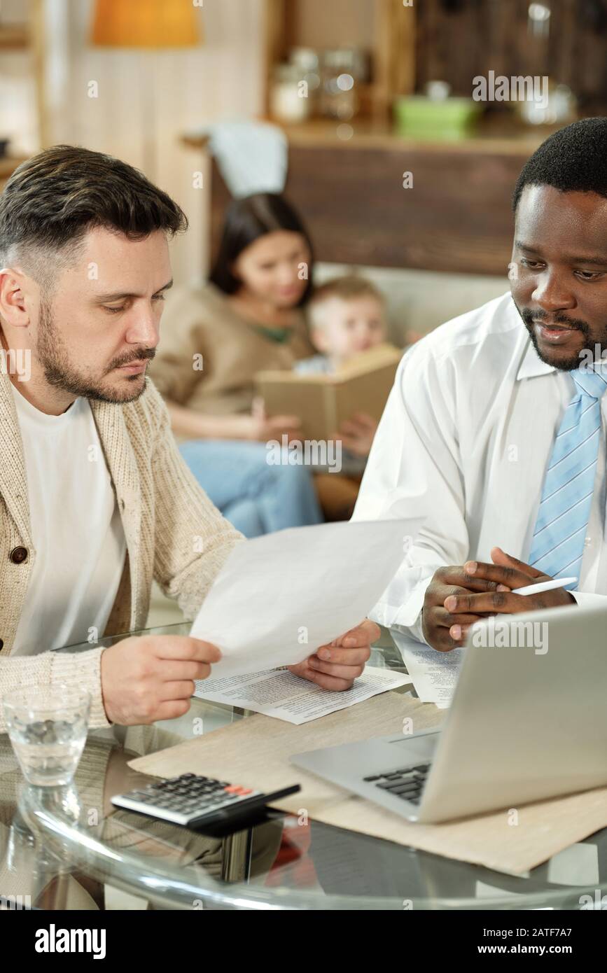 Adult men discussing home loan at table Stock Photo