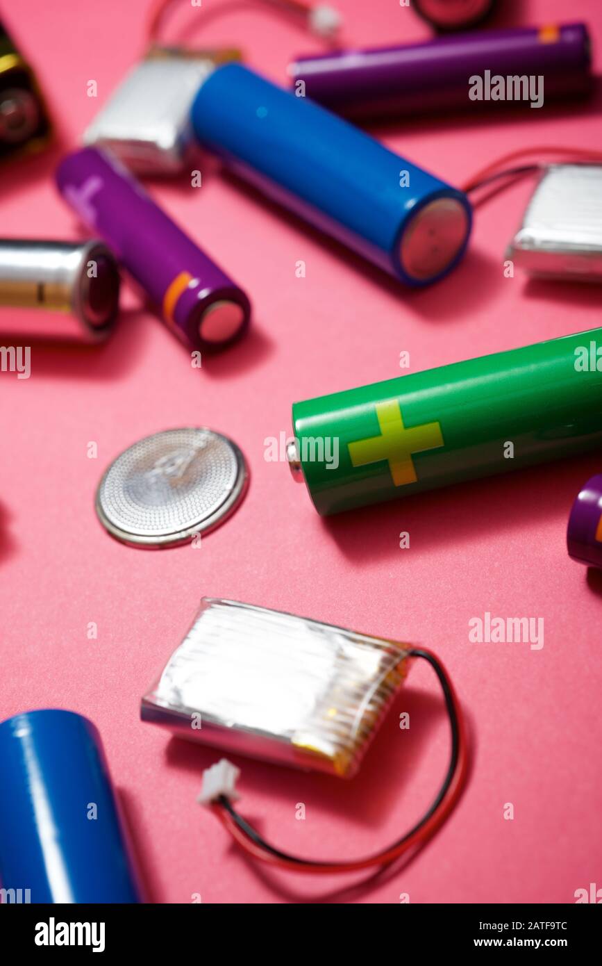 Many batteries on a pink table. Stock Photo