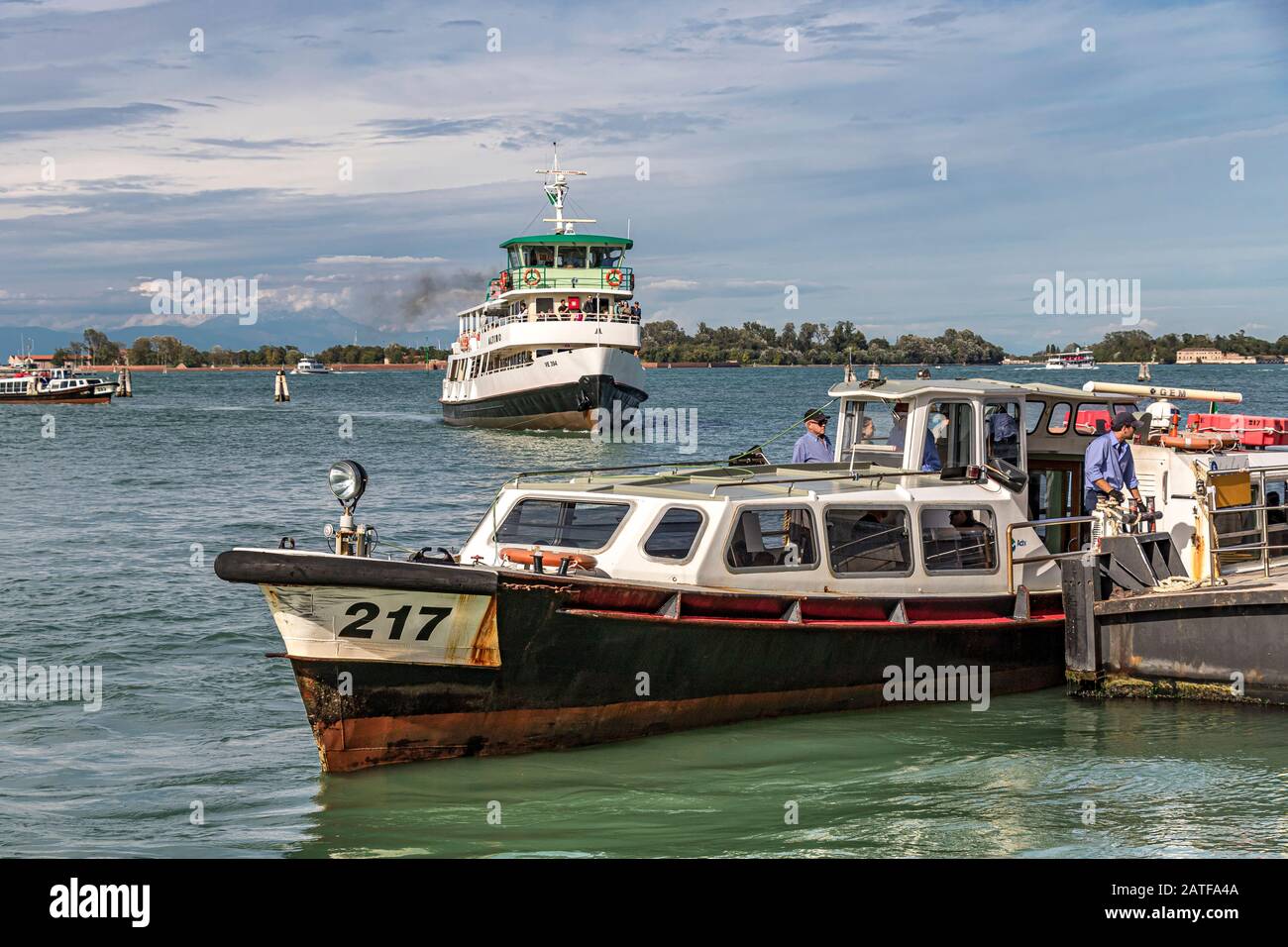 A route14 vaporetto or water bus at the Lido Vaporetto stop as the ferry Altino approaches in the distance on The Venice lagoon ,Venice .Italy Stock Photo