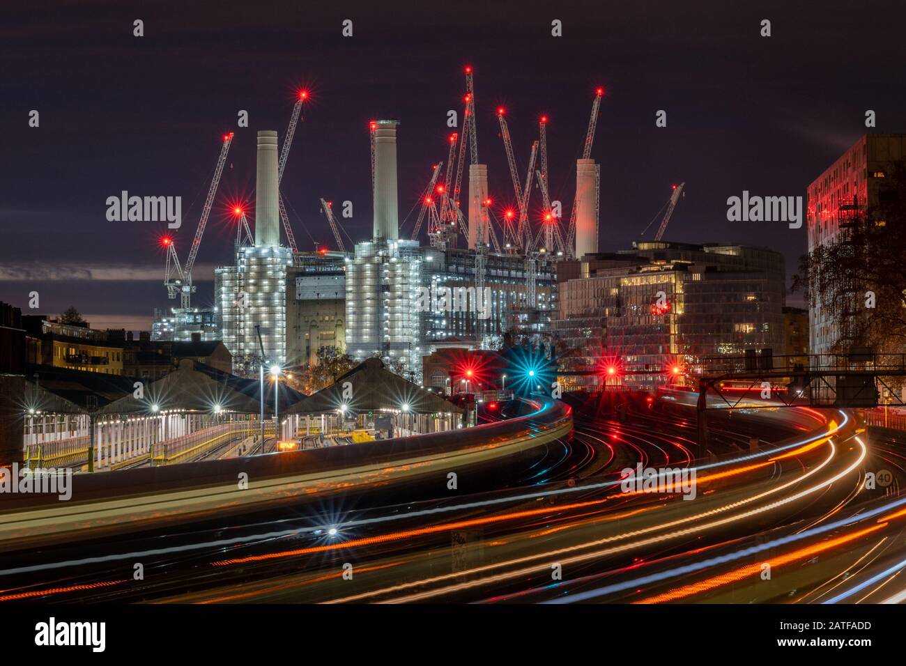 London. A moody night photograph of Battersea Power Station showing light trails from the trains. Stock Photo