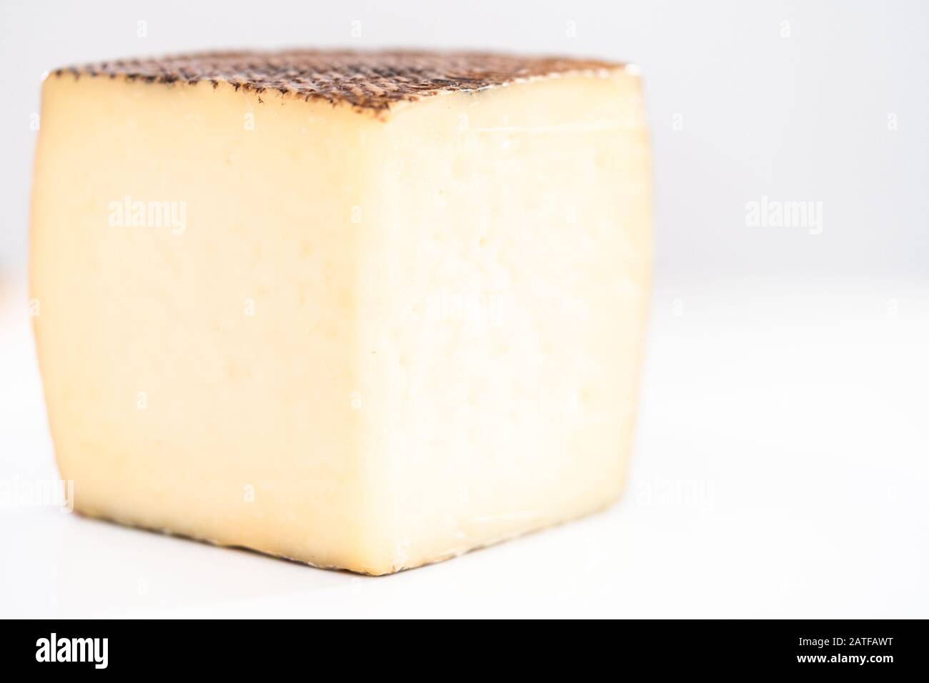 Large slice of aged Manchego cheese on a white background Stock Photo ...