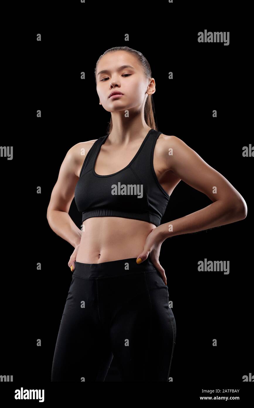 Young fit sportswoman keeping her hands on waist during physical training Stock Photo