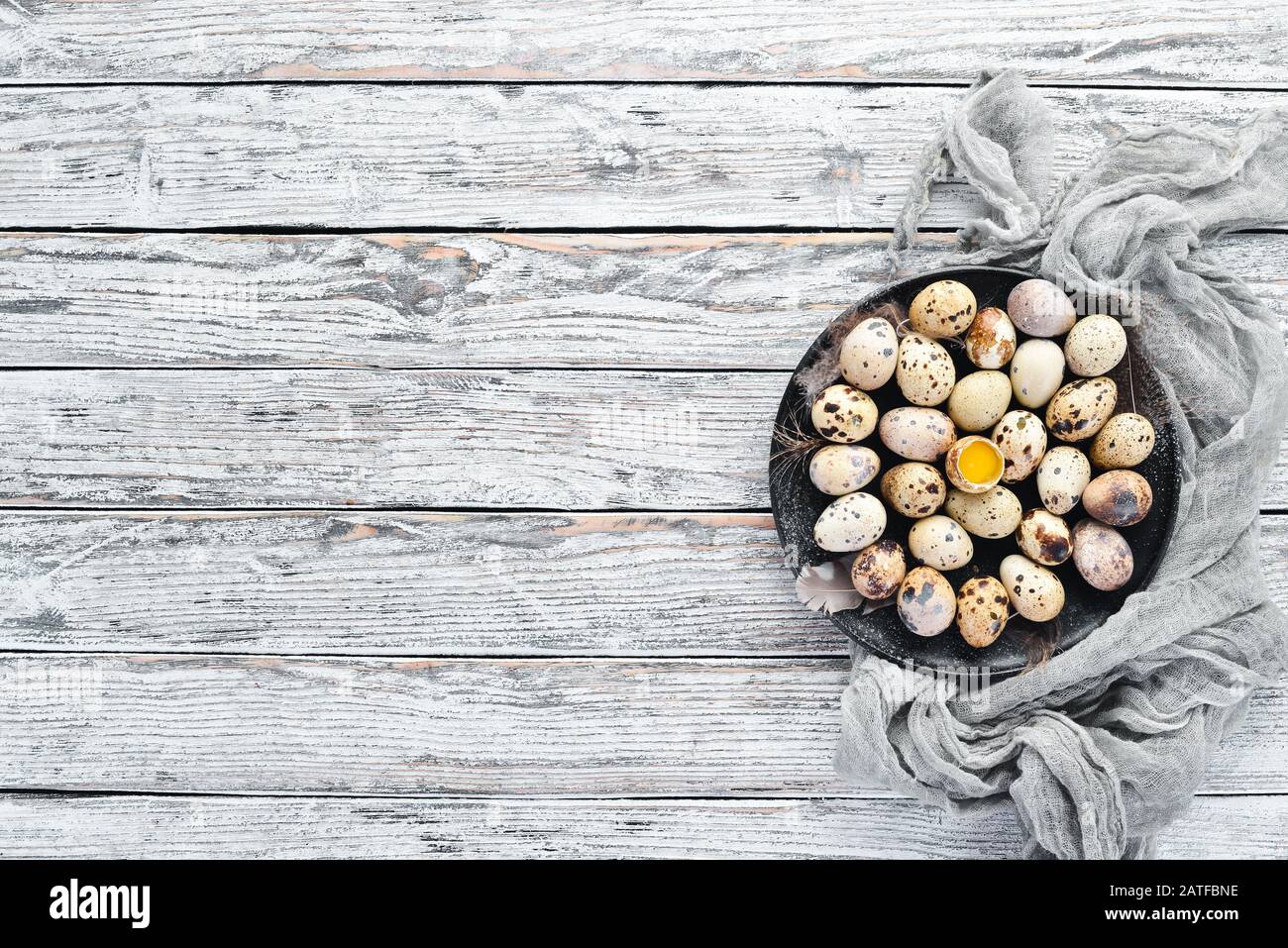 Quail eggs in a black plate. On the old background. Top view. Free copy space. Stock Photo