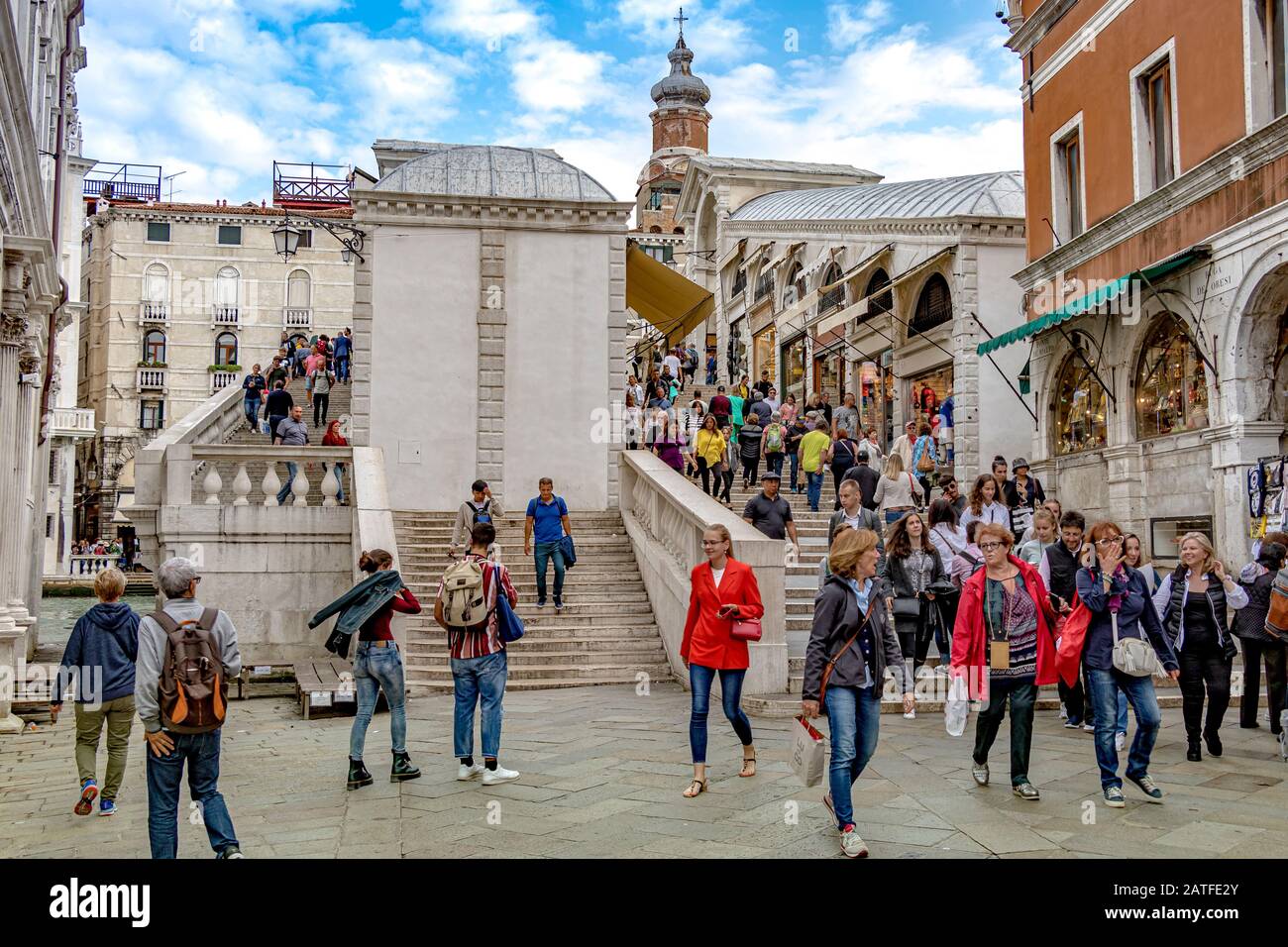 Visitors And Tourists Walking Down From The Rialto Bridge In Venice