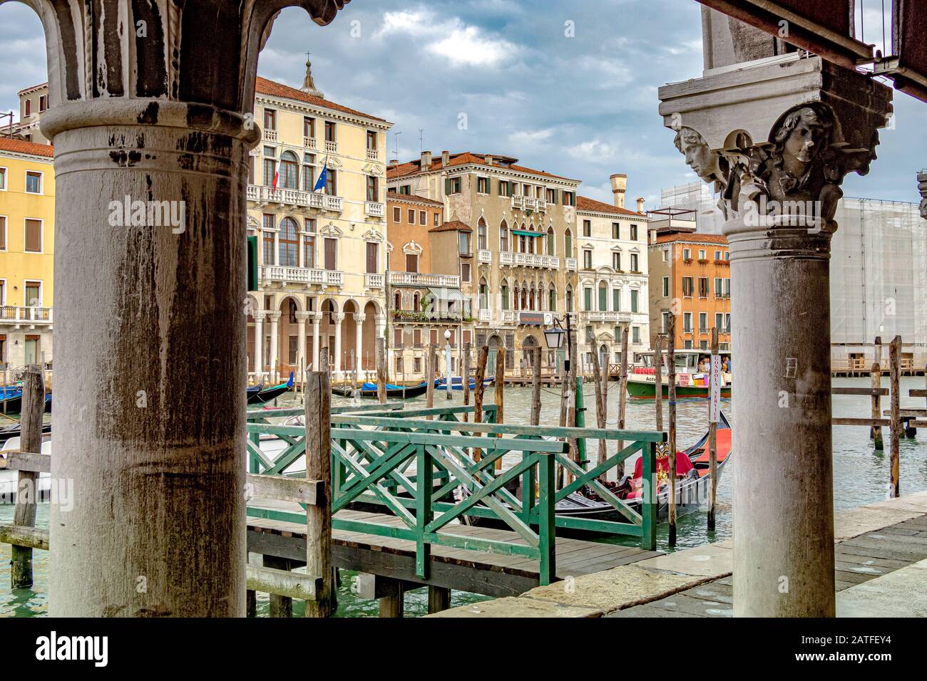 A boat jetty through a pair of stone pillars on The Grand Canal In Venice with the baroque Palazzo Michiel an art museum in the background in Venice Stock Photo