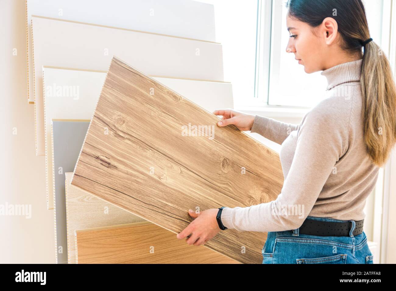 home repair. portrait of woman choosing wood laminated flooring in shop Stock Photo