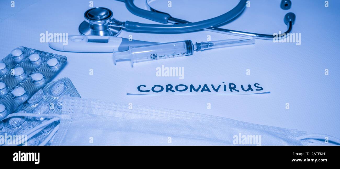 New coronavirus-2019-nCoV. Medical blue background with inscription coronavirus, stethoscope, pills, thermometer, syringe. Stock Photo