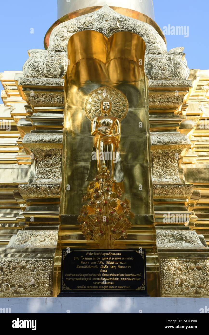 Golden statue of the Buddha at  the base of the chedi of Wat Chai Mongkhon, Chiang Mai, Thailand Stock Photo