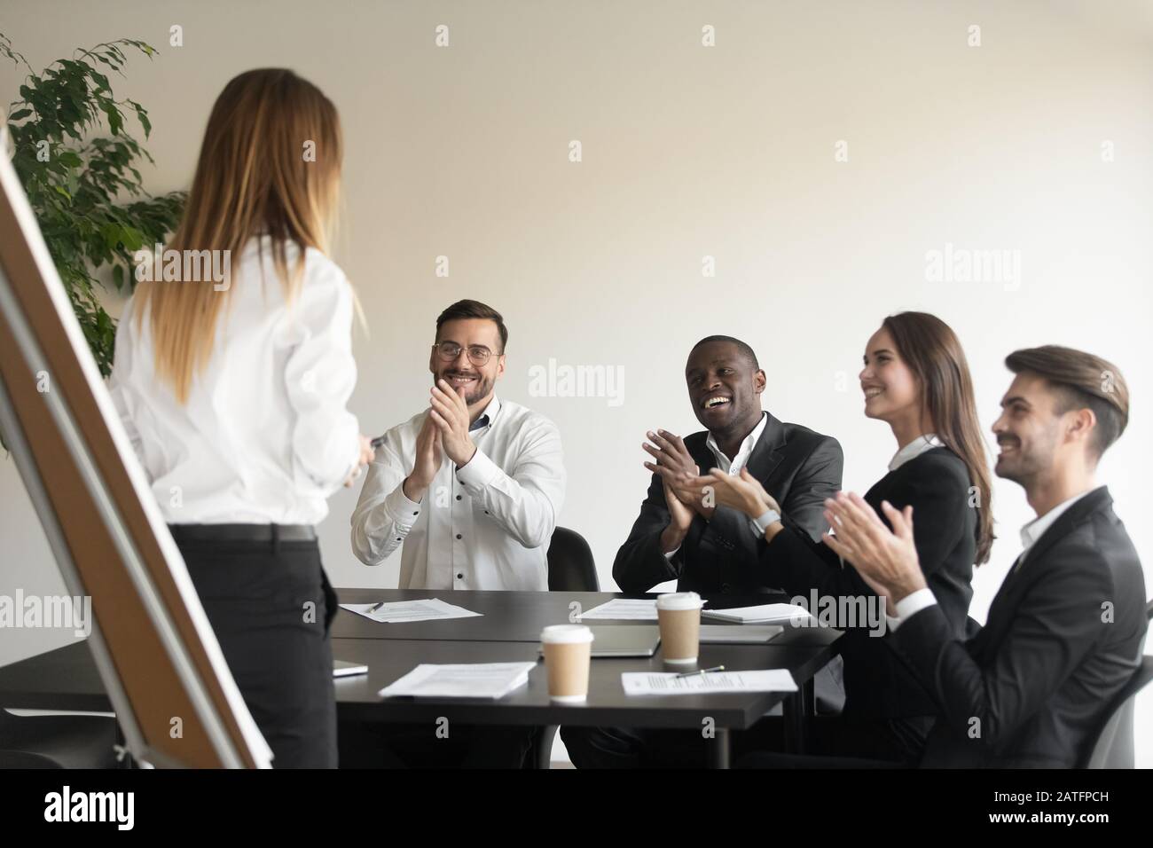 Employees clap hands showing respect and appreciation to business coach Stock Photo