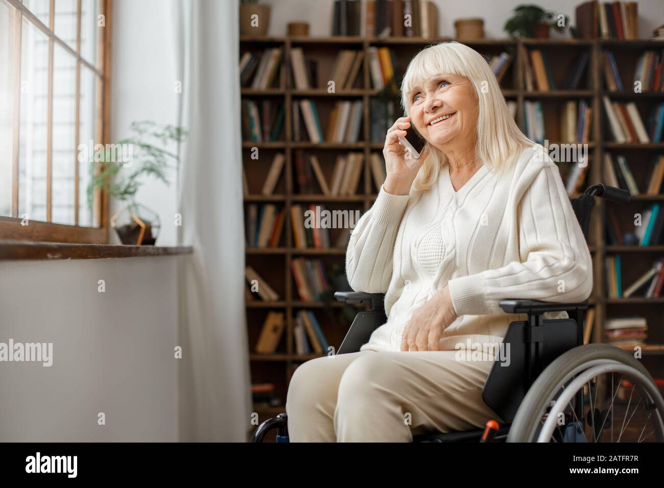 Senior woman with disability recovery at home wheelchair phone call ...
