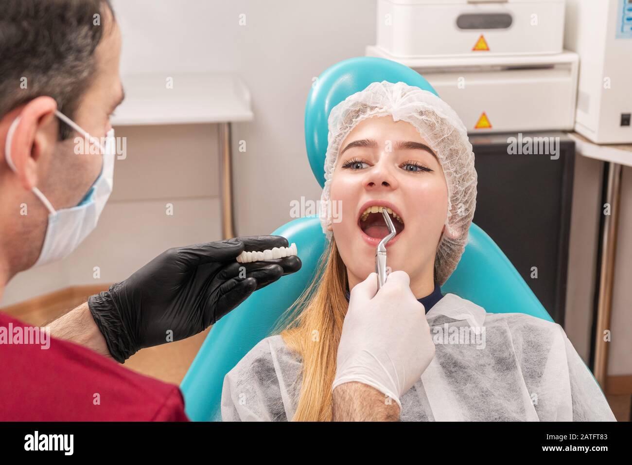 dentist grasped with forceps for a front tooth to pull it and put the