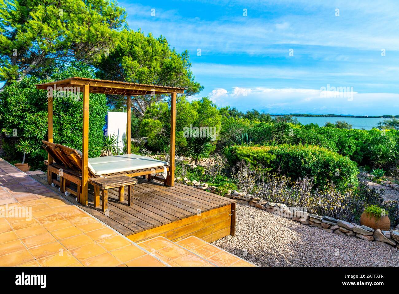 Sun lounger canopy bed looking out to Estany Pudent Salt lagoon lake, Formentera, Spain Stock Photo