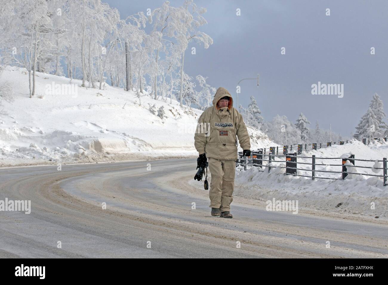 Photographer in the winter on the road Stock Photo
