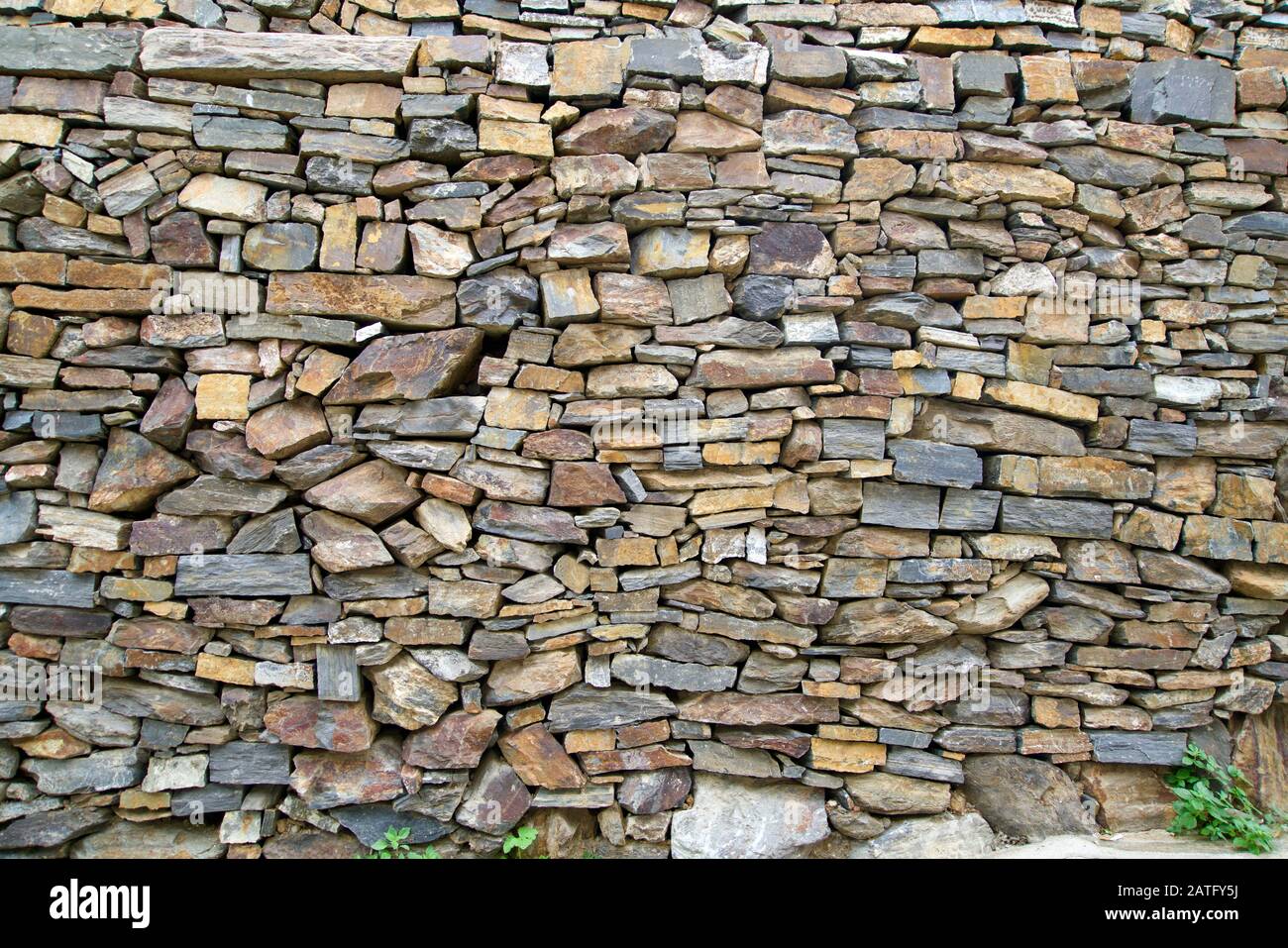 Background of a wall of small natural stones Stock Photo