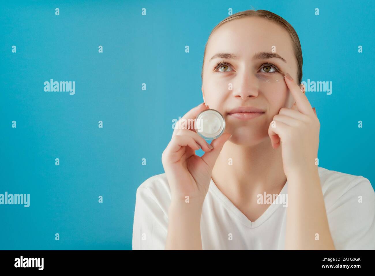 Portrait Of Joyful Girl Covering Her Eye By A Cream Can She Is Looking